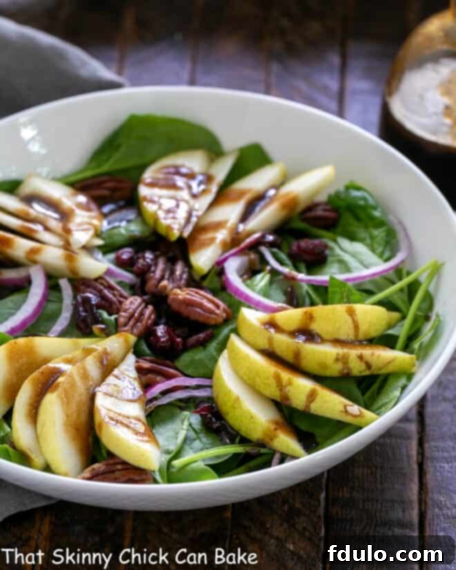 White bowl with spinach pear salad.