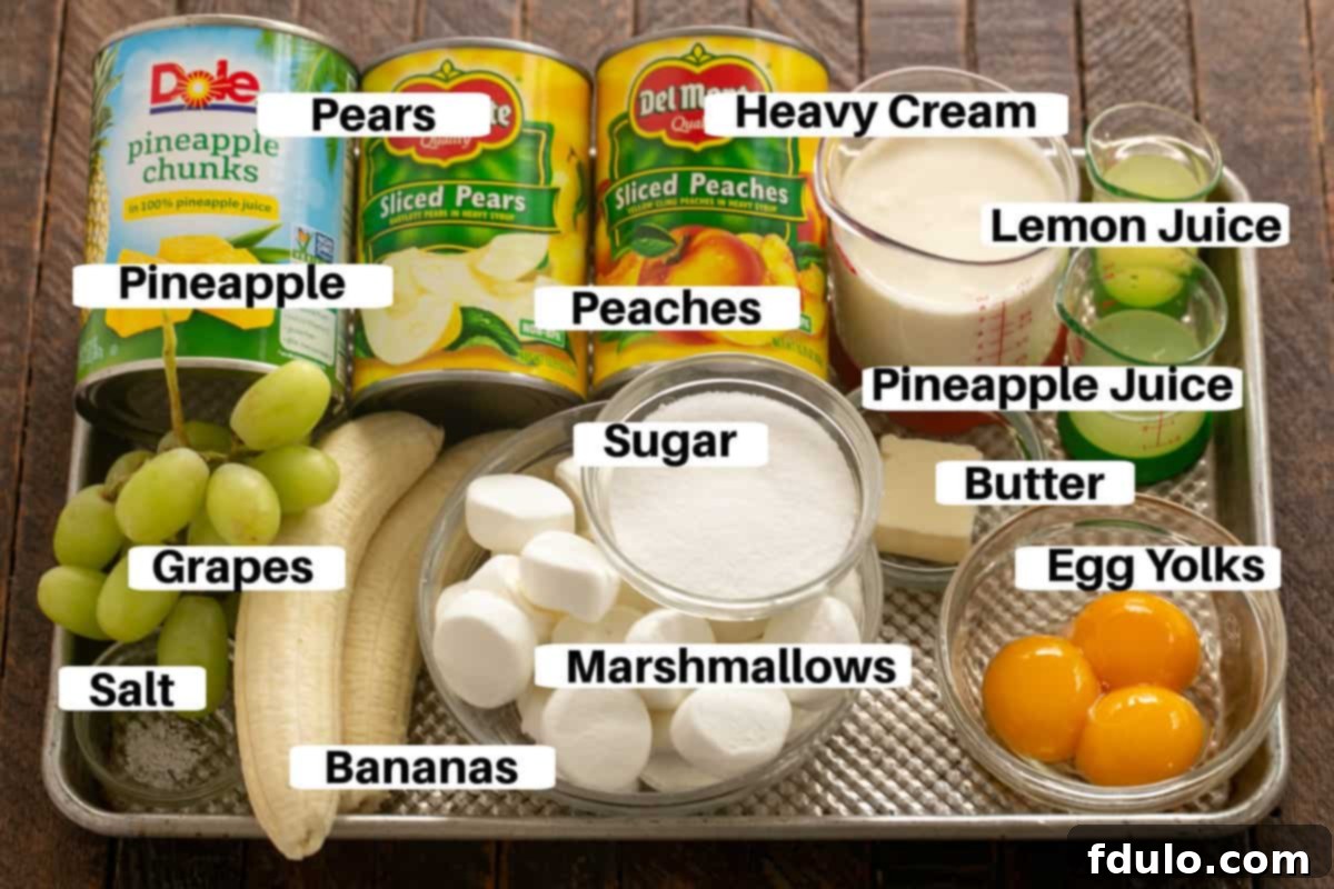 Ingredients for overnight fruit salad laid out neatly on a metal sheet pan with clear labels.