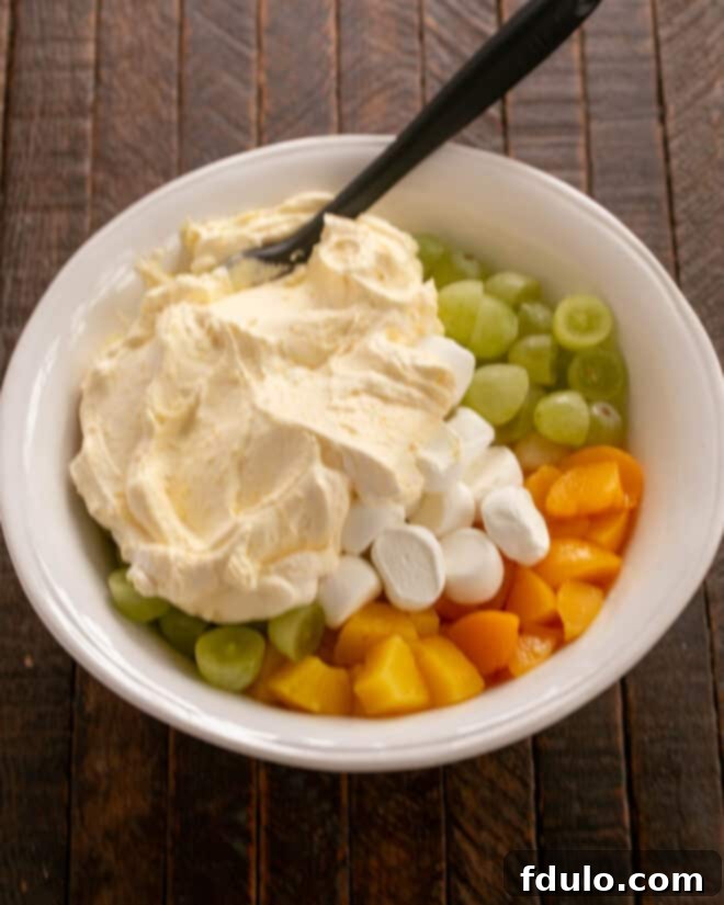 Adding whipped cream dressing to fruit.