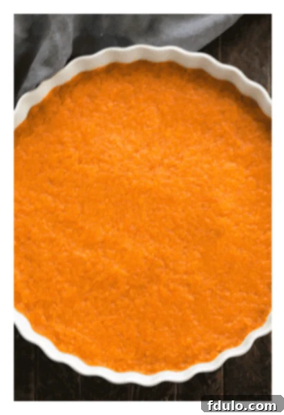 Sweet potato filling ingredients being mixed in a bowl, before being spread into a baking dish.