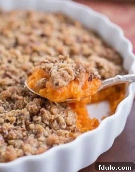 Praline Topped Sweet Potato Casserole baking in the oven, with a golden-brown crust forming.