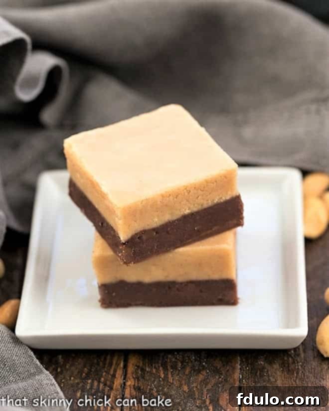 Two perfectly cut squares of easy peanut butter fudge, showcasing the rich, creamy texture and inviting golden color.