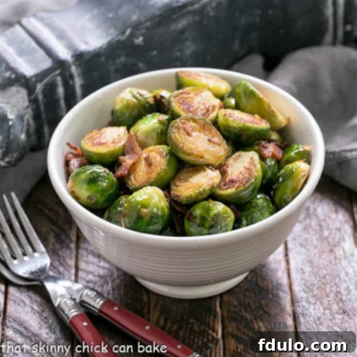 Pan brussels sprouts in a white bowl with 2 forks
