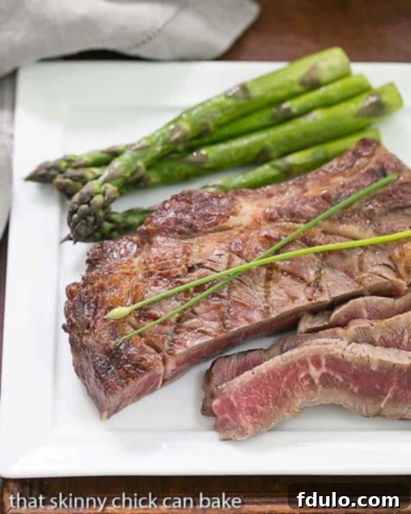 Perfectly Sliced Grilled Rib Eye Steaks on a square white plate, showing an ideal medium-rare doneness.