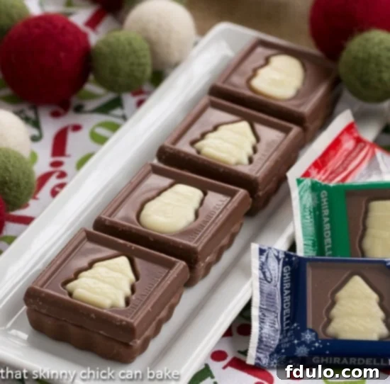 A festive display of delicate fudge snowflakes and classic chocolate fudge squares arranged on an elegant white rectangular tray, perfect for holiday entertaining.