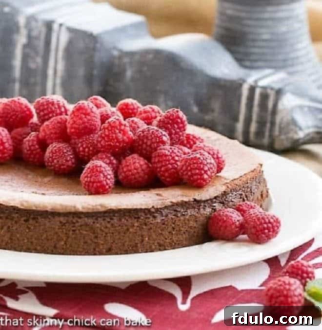 Chocolate Mousse Torte covered with fresh raspberries, showcasing its rich texture and festive topping