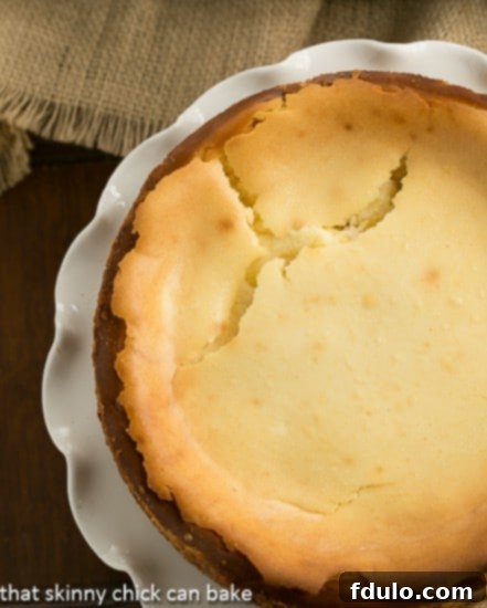 Close-up of a Lemon Bar Cheesecake showing a crack on the surface after baking, demonstrating how it will be covered by topping.