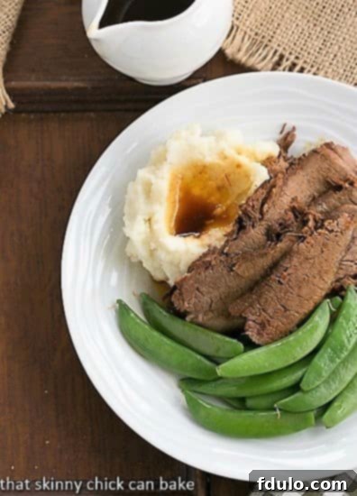 Coffee Glazed Brisket - A slow cooked, tender and flavorful beef brisket recipe! A delicious serving of Coffee Glazed Brisket, accompanied by vibrant sugar snap peas and creamy mashed potatoes on a white plate, viewed from above.