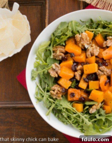 Arugula Salad with Roasted Butternut Squash from above in a white bowl with a side of Parmesan shavings, ready to serve and enjoy.