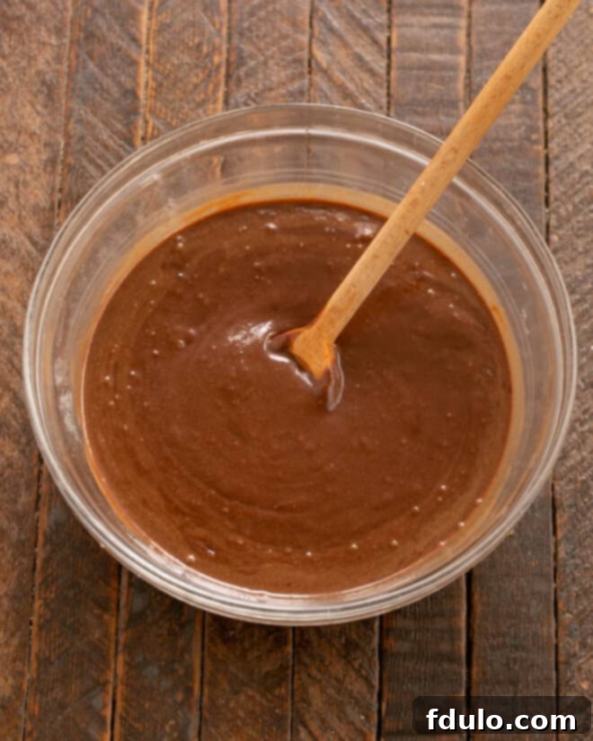 Step 7: Pouring hot water into the cake batter and stirring.