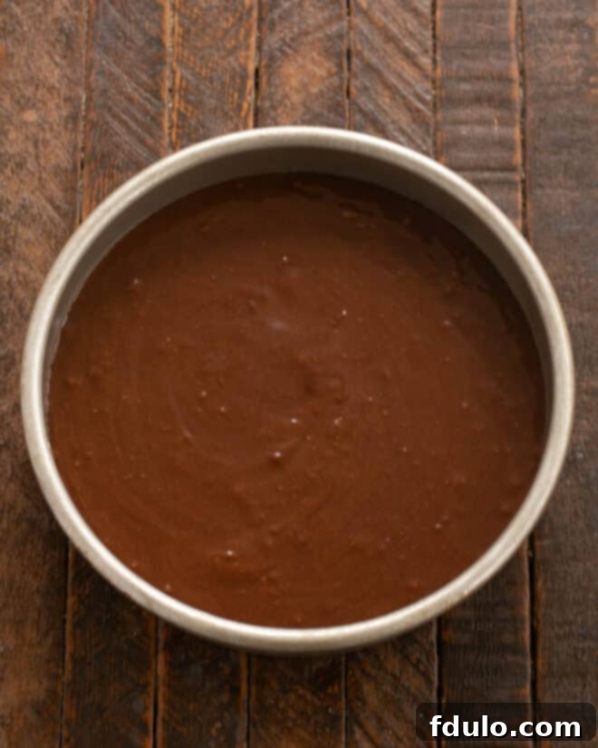 Step 8: Scraping cake batter into the prepared pan.