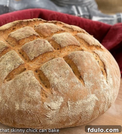 A golden-brown Country Bread loaf resting on a rustic wooden cutting board, highlighting its substantial size and appealing crust.