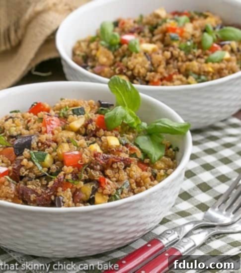 Two pristine white bowls filled with a delightful Quinoa Salad with Roasted Vegetables, highlighting the fresh, wholesome ingredients.