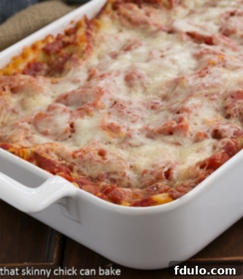 A large rectangular baking dish filled with Easy Sausage and Mushroom Lasagna, fresh out of the oven, with a bubbling, golden-brown cheese topping.
