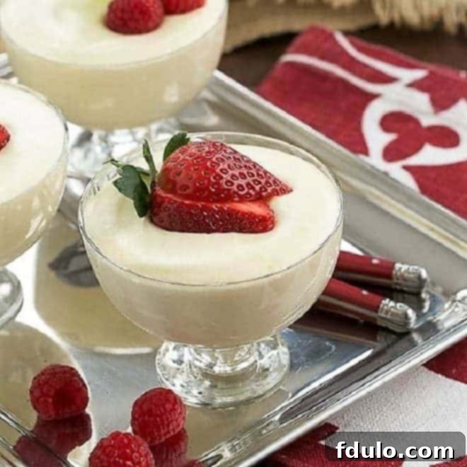 Dreamy White Chocolate Mousse spiked with Frangelico in elegant glass dishes topped with fresh berries and mint