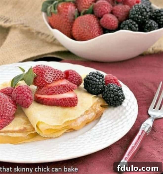 Butter and Rum Crêpes filled with bright lemon curd and topped with fresh, colorful berries. A luxurious dessert or brunch option.