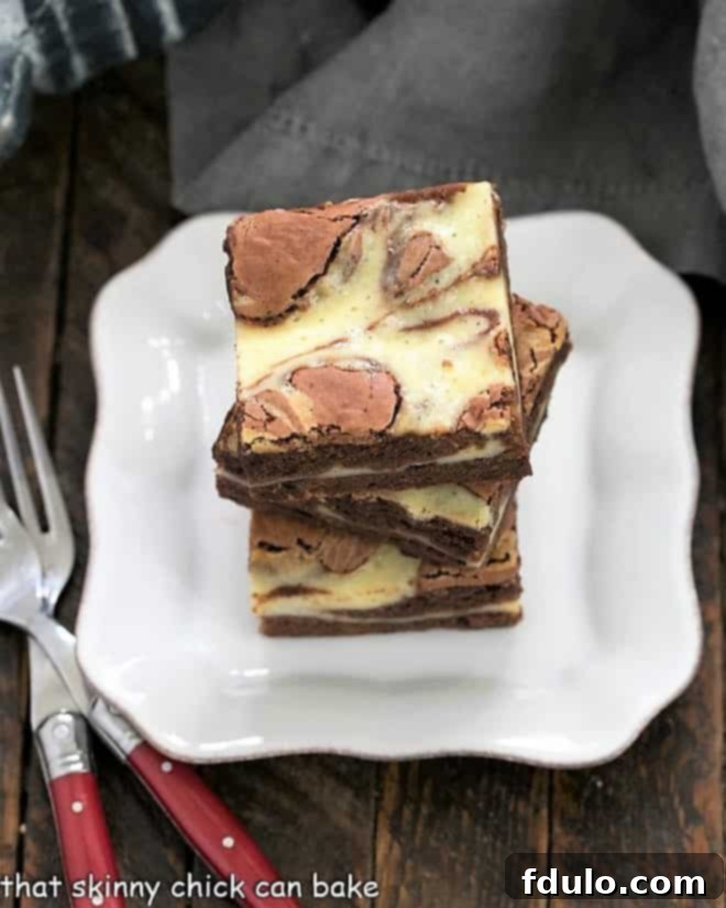 3 Cheesecake Swirl Brownies stacked on a small plate.