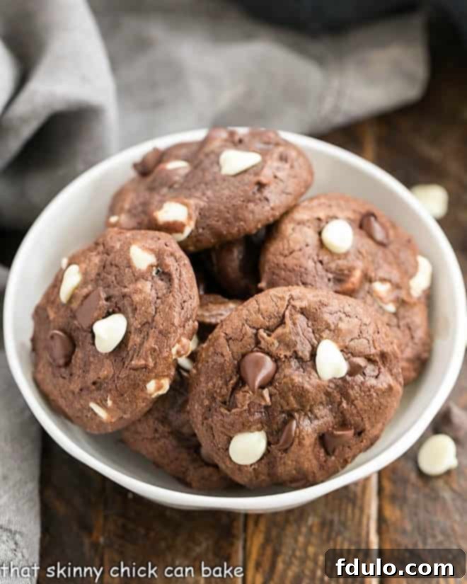 Overhead view of a bowl filled with freshly baked Brownie Drop Cookies, glistening with chocolate.