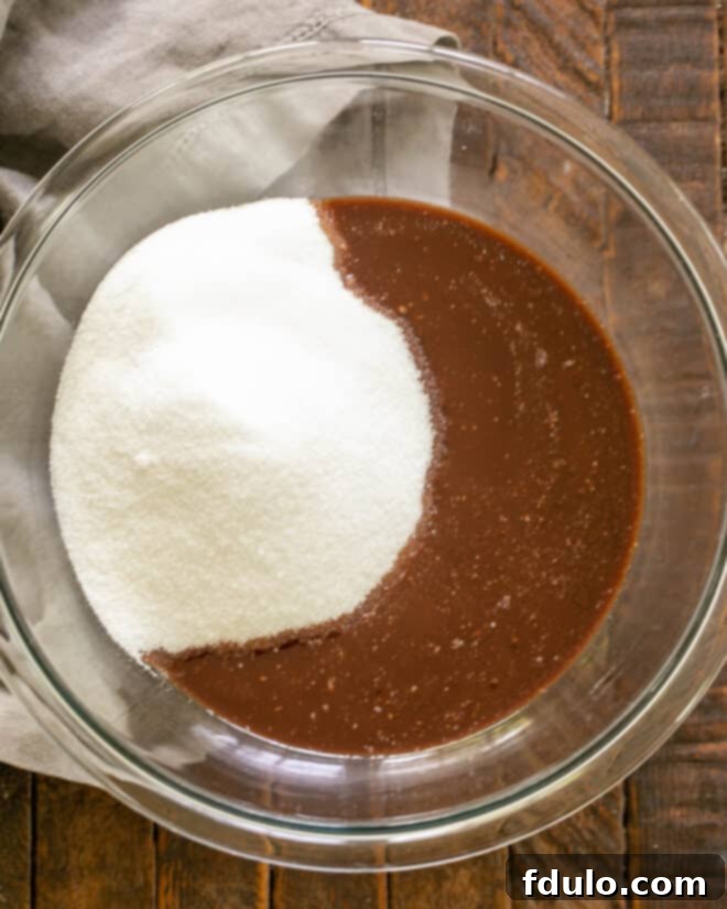 Adding sugar to the melted chocolate and butter mixture.