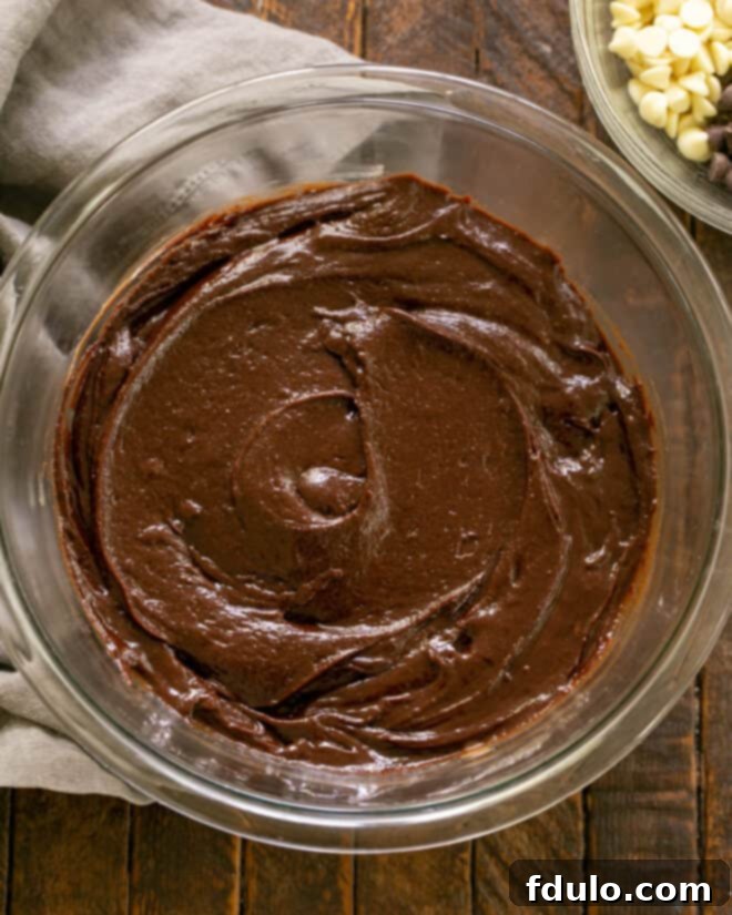 Mixing eggs and vanilla into the chocolate mixture.