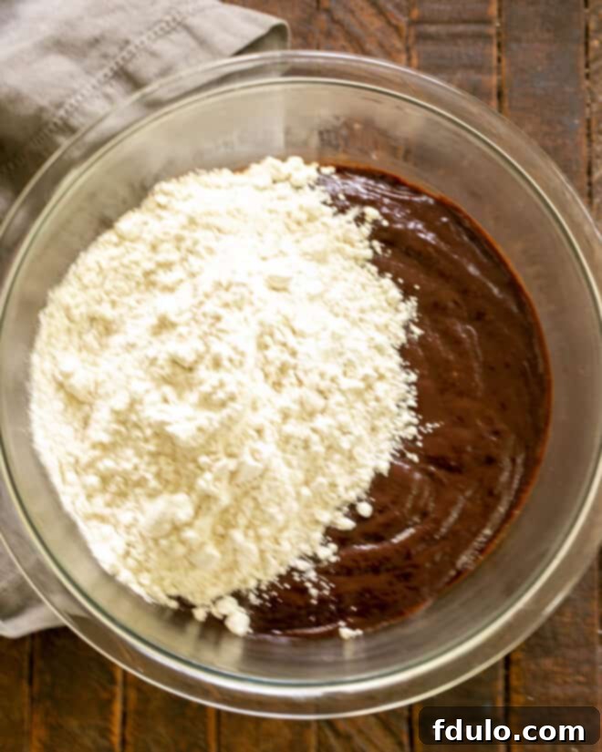 Adding flour to the wet ingredients and mixing.