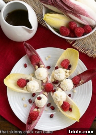 Overhead view of a star-shaped arrangement of Endive Cups with Blue Cheese, Raspberries, and Macadamia Nuts, showcasing their elegant presentation.