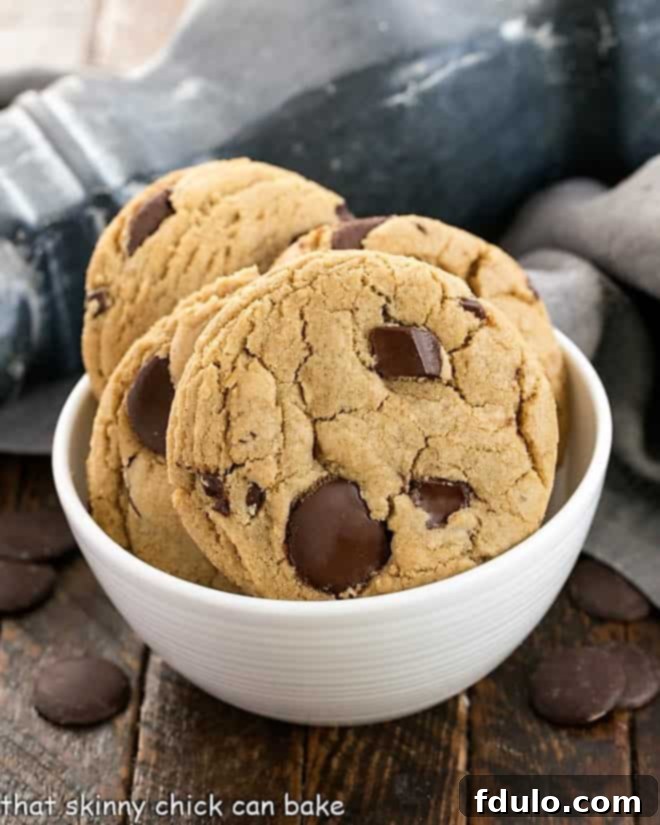 Jumbo Chocolate Chip Cookies - Big, chewy chocolate chip cookies with caramel undertones! Jumbo Chocolate Chips in a white ceramic bowl, ready to be baked into delicious cookies.