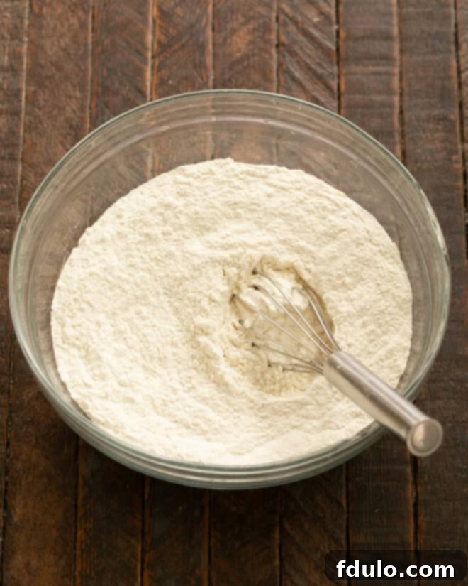 Colossal Chocolate Chip Cookies 3 Dry ingredients in a bowl with a whisk, ready to be combined.