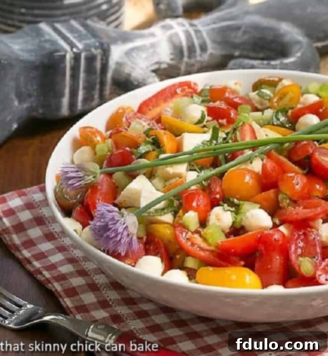 Caprese Salad with Chicken presented beautifully in a white serving bowl, showcasing its fresh and vibrant ingredients.