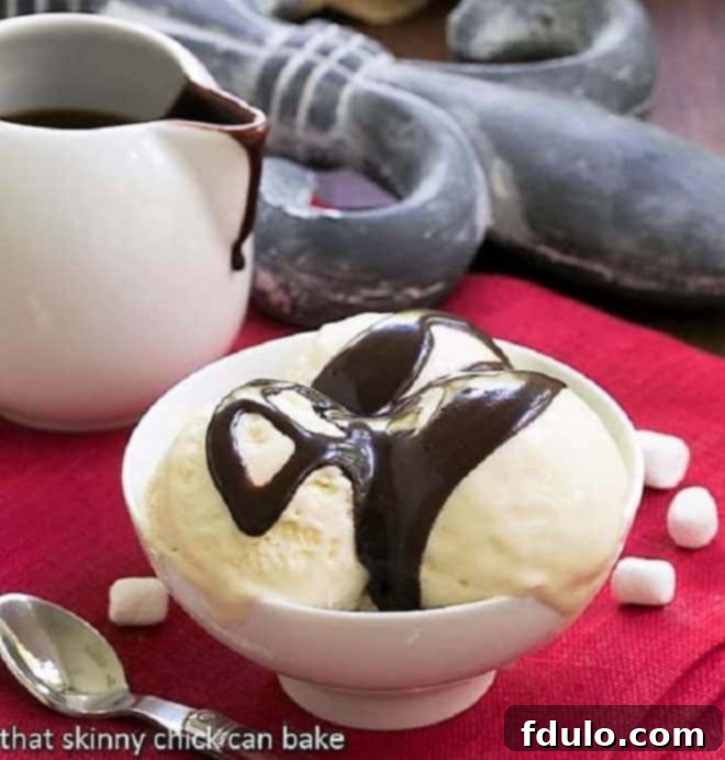 Dreamy, rich and luscious Fudge Topped Marshmallow Ice Cream is the perfect summer treat! Fudge Topped Marshmallow Ice Cream in a white dessert bowl
