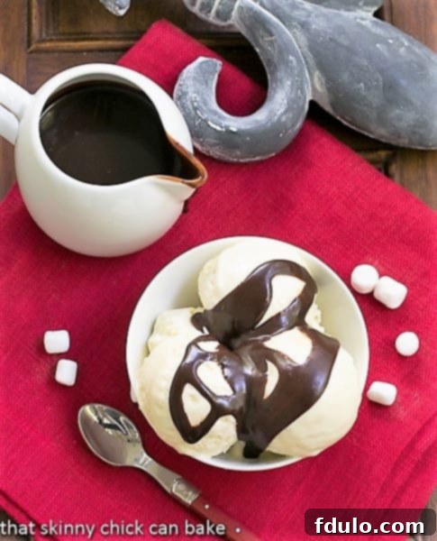 Fudge Topped Marshmallow Ice Cream - a delicious twist on the classic hot fudge sundae Overhead view of Fudge Topped Marshmallow Ice Cream Sunday with a pitcher of fudge sauce