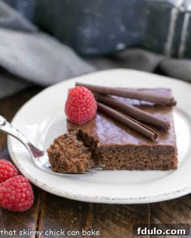 Chocolate Syrup Brownies on a round white plate with a fork with a bite of cake on the tines.