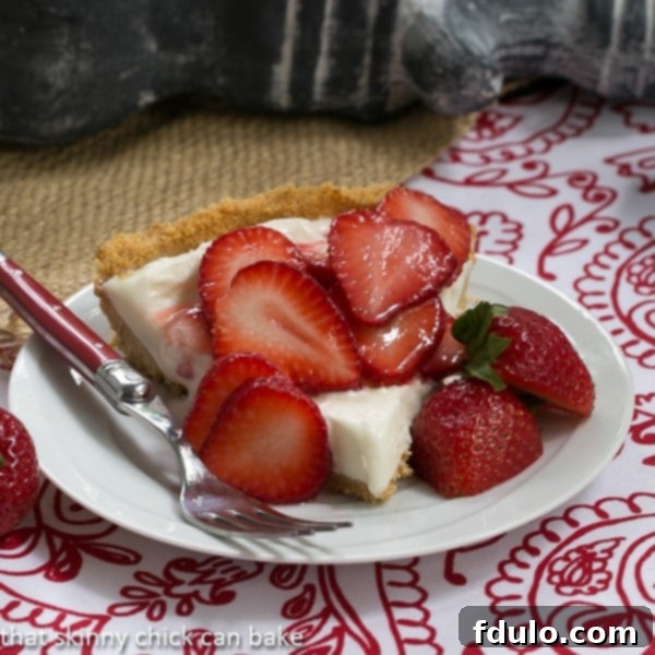 A slice of creamy Strawberry Cheesecake Ice Cream Pie with a graham cracker crust, showcasing a perfect blend of fruit and cheesecake flavors, an alternative way to enjoy this ice cream.