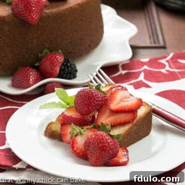 Vanilla Pound Cake - Perfect dessert topped with summer berries or any seasonal topping Slice of Vanilla Pound Cake on a white dessert plate topped with berries.
