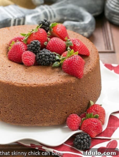 Vanilla Pound Cake - Perfect dessert topped with summer berries or any seasonal topping Whole Vanilla Pound Cake on a white ruffled plate topped with berries.