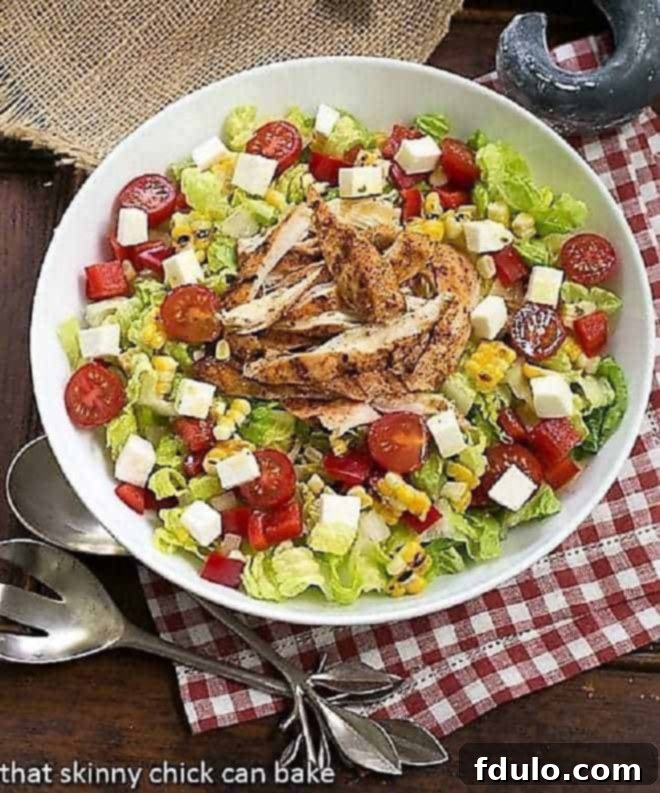 Overhead view of a vibrant Southwestern Chicken Salad in a white bowl, showcasing all the colorful ingredients.