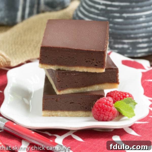 Truffle Brownies stacked on a white square plate, showcasing their rich layers.