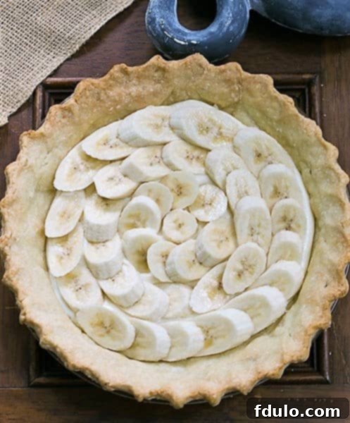 Banana Cream Cheesecake Pie with crust and layer of bananas.