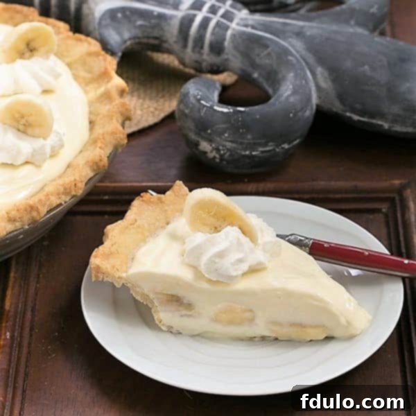 Slice of Banana Cream Cheesecake Pie on a white dessert plate.