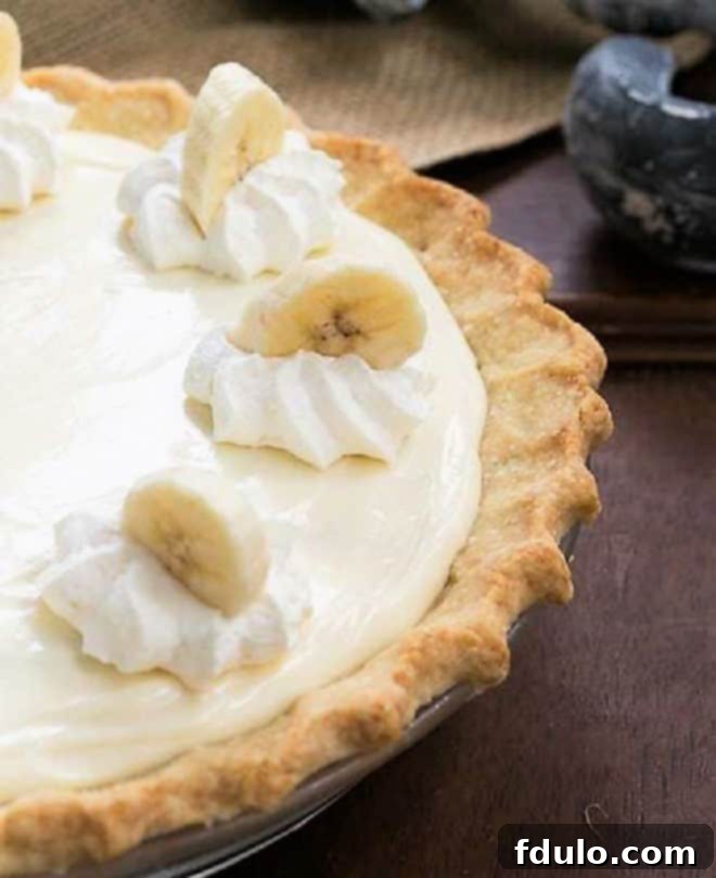 Banana Cream Cheesecake Pie close up view of pie and whipped cream and banana slice garnishes