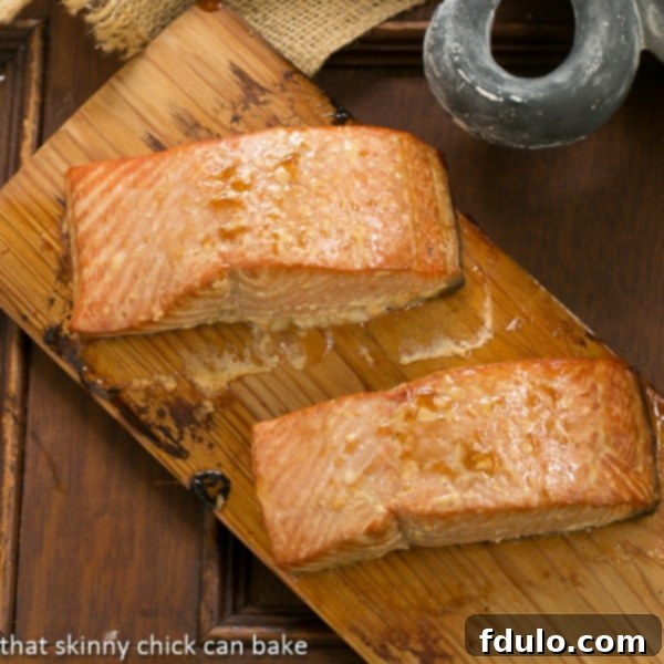 This Grilled Cedar Plank Salmon, infused with a simple marinade, offers an elegant and flavorful seafood entree. Two fillets of perfectly grilled Cedar Plank Salmon resting on a cedar plank, showcasing a beautiful golden-brown crust.