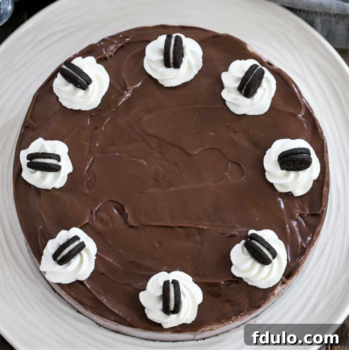 A complete Fudge Topped Chocolate Ice Cream Pie, featuring an Oreo crust, rich chocolate ice cream, and a glossy fudge sauce topping, ready to be served. A perfect summer dessert.