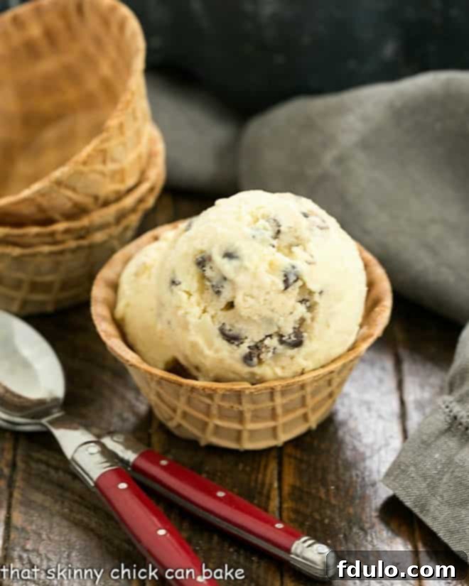 A scoop of smooth brown sugar ice cream studded with delicious chunks of edible cookie dough.