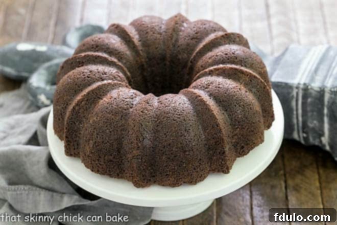 Decadent Chocolate Zucchini Bundt 2 Chocolate Zucchini Bundt Cake on a white cake stand