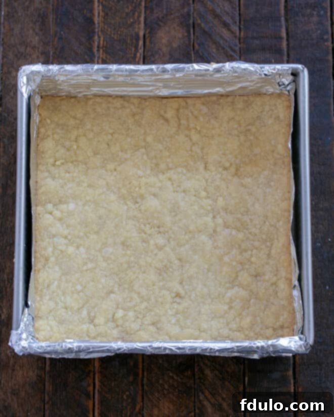 Golden Caramel Squares 7 The shortbread crust is baking in an oven, turning golden brown.