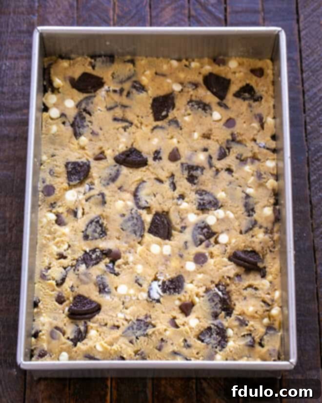 Ultimate Oreo Chocolate Chip Bars 8 Step 6: Spreading the cookie dough into a prepared baking pan.
