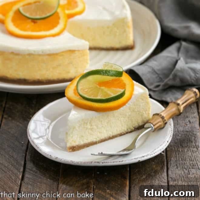 Margarita Cheesecake - An exquisite citrus cheesecake with the flavors of a margarita! A full Margarita Cheesecake with a slice removed, displaying its creamy texture and the golden-brown crust. Garnished beautifully with orange and lime slices.