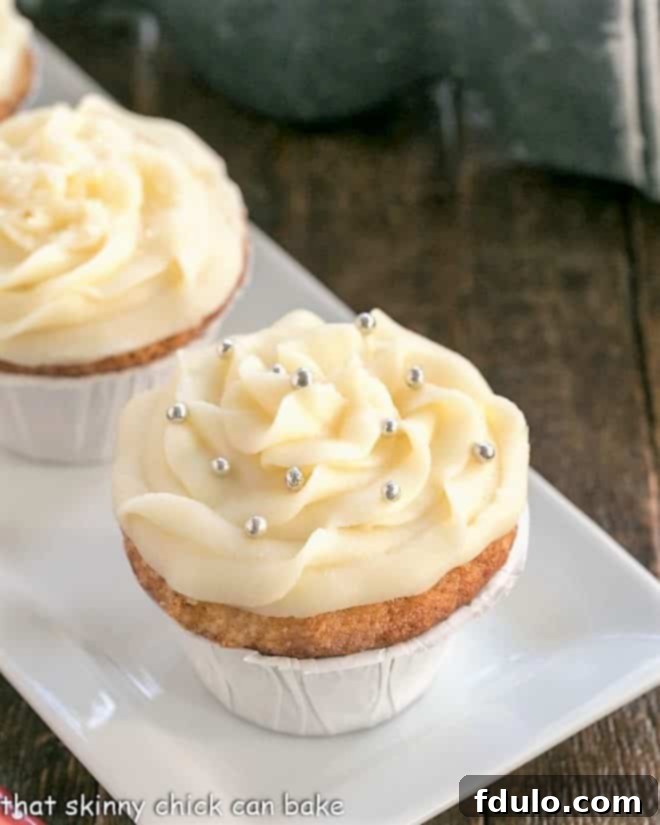 Beautifully piped vanilla cupcakes on a pristine white serving tray, ready to be enjoyed.