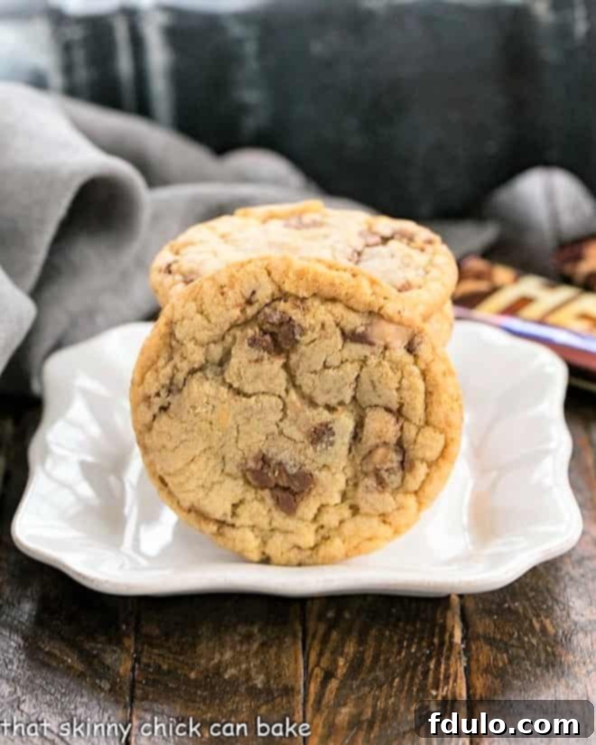 A close-up of Brown Butter Toffee Cookies on a small square ceramic plate, highlighting the delightful toffee pieces.