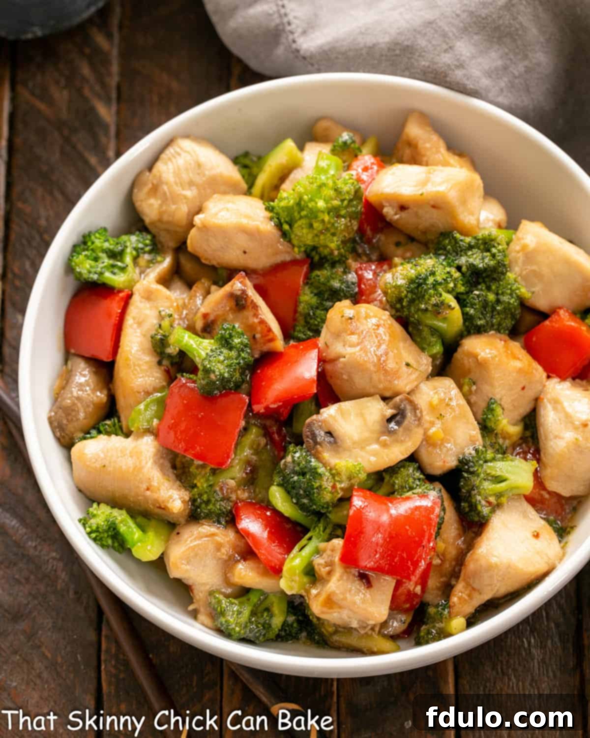 An inviting overhead view of a generously sized serving bowl filled with a vibrant chicken and broccoli stir fry, ready for enjoyment.